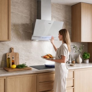 Weiße CIARRA Kopffreihaube 60 cm mit Gestensteuerung in moderner Küche. Frau bedient Dunstabzugshaube mit LED-Licht.