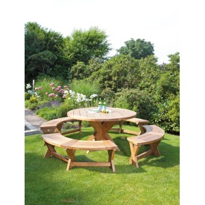 Runder Natur24 Quantum Gartentisch aus Teakholz mit passenden Bänken im Garten.
