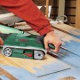 Bosch PBS 75 A Bandschleifer in Aktion beim Schleifen einer blauen Holztür.