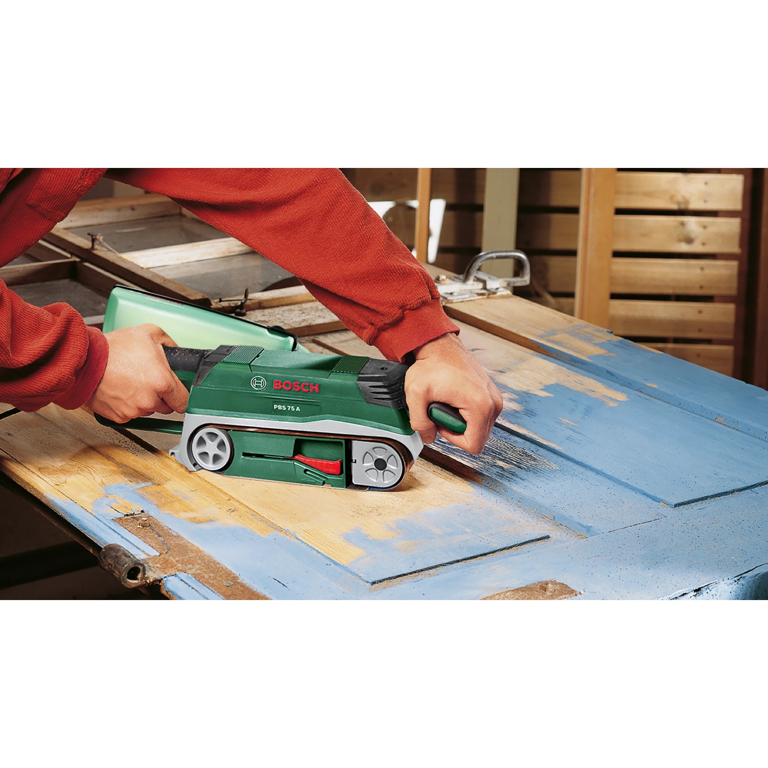 Bosch PBS 75 A Bandschleifer in Aktion beim Schleifen einer blauen Holztür.