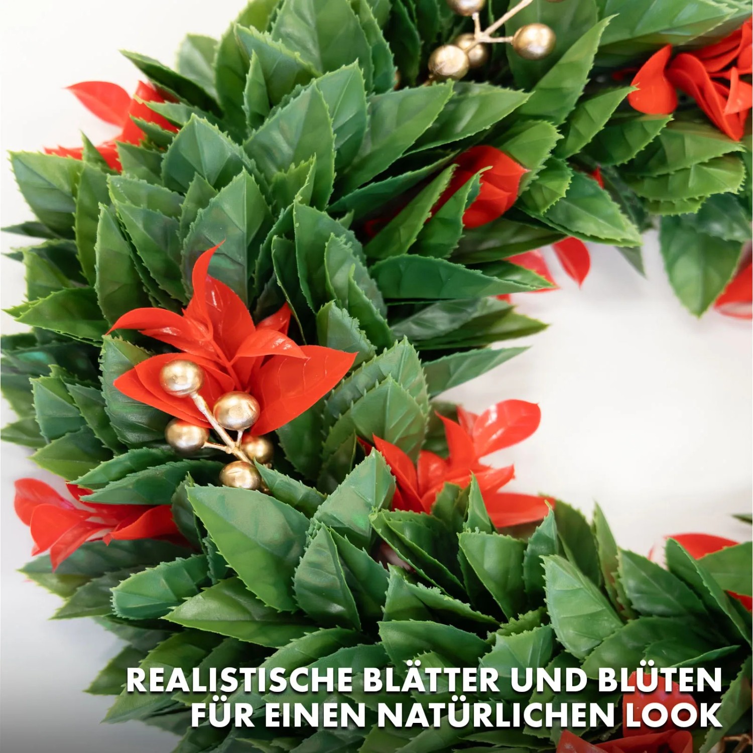 Detailansicht: Weihnachtskranz Photinia mit grünen Blättern, roten Blüten und goldenen Beeren.