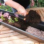 Floraworld Wasserspeichermatte im Blumenkasten mit Erde und Pflanzen.