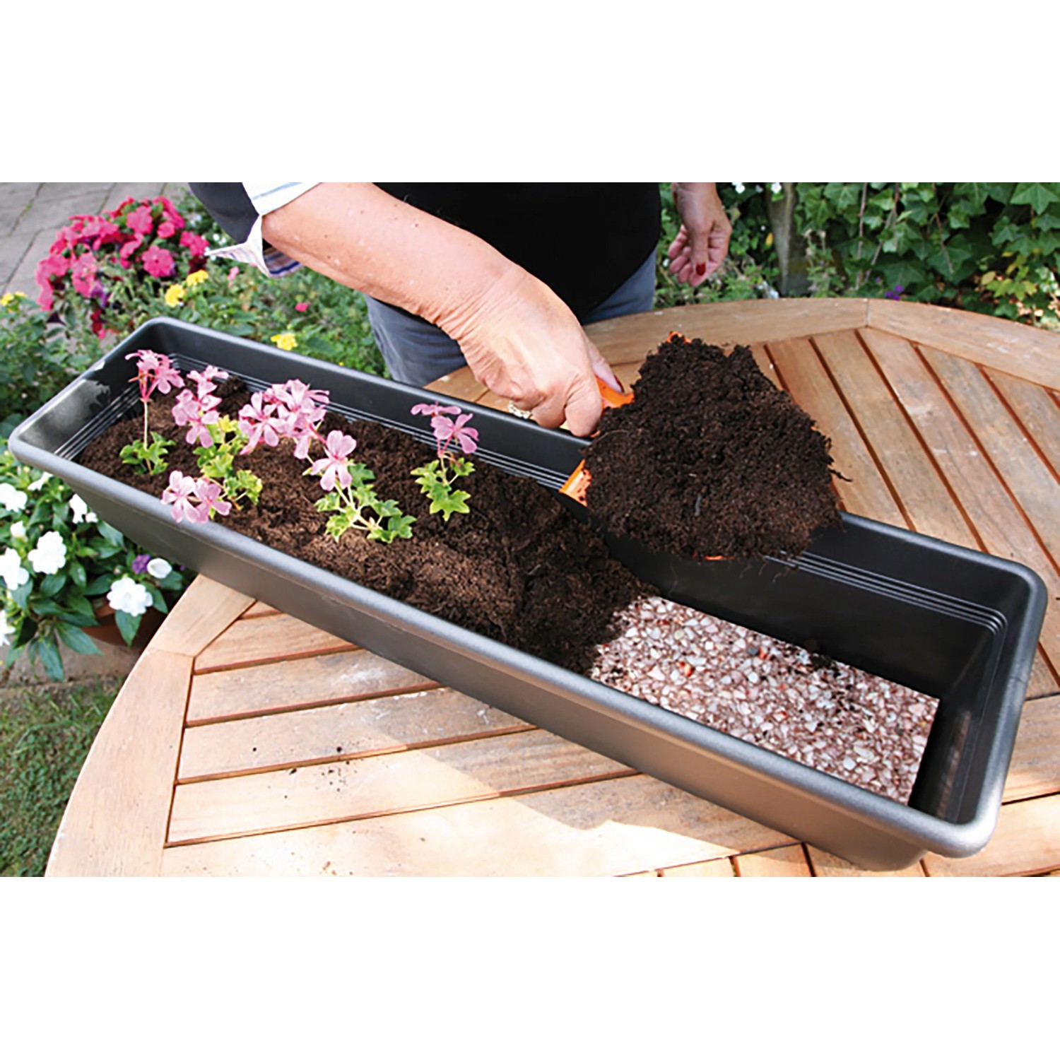 Floraworld Wasserspeichermatte im Blumenkasten mit Erde und Pflanzen.