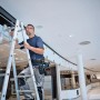 Handwerker auf Leiter mit Bosch Werkzeugtasche GWT 2 am Gürtel. Werkzeugkoffer für Profis.