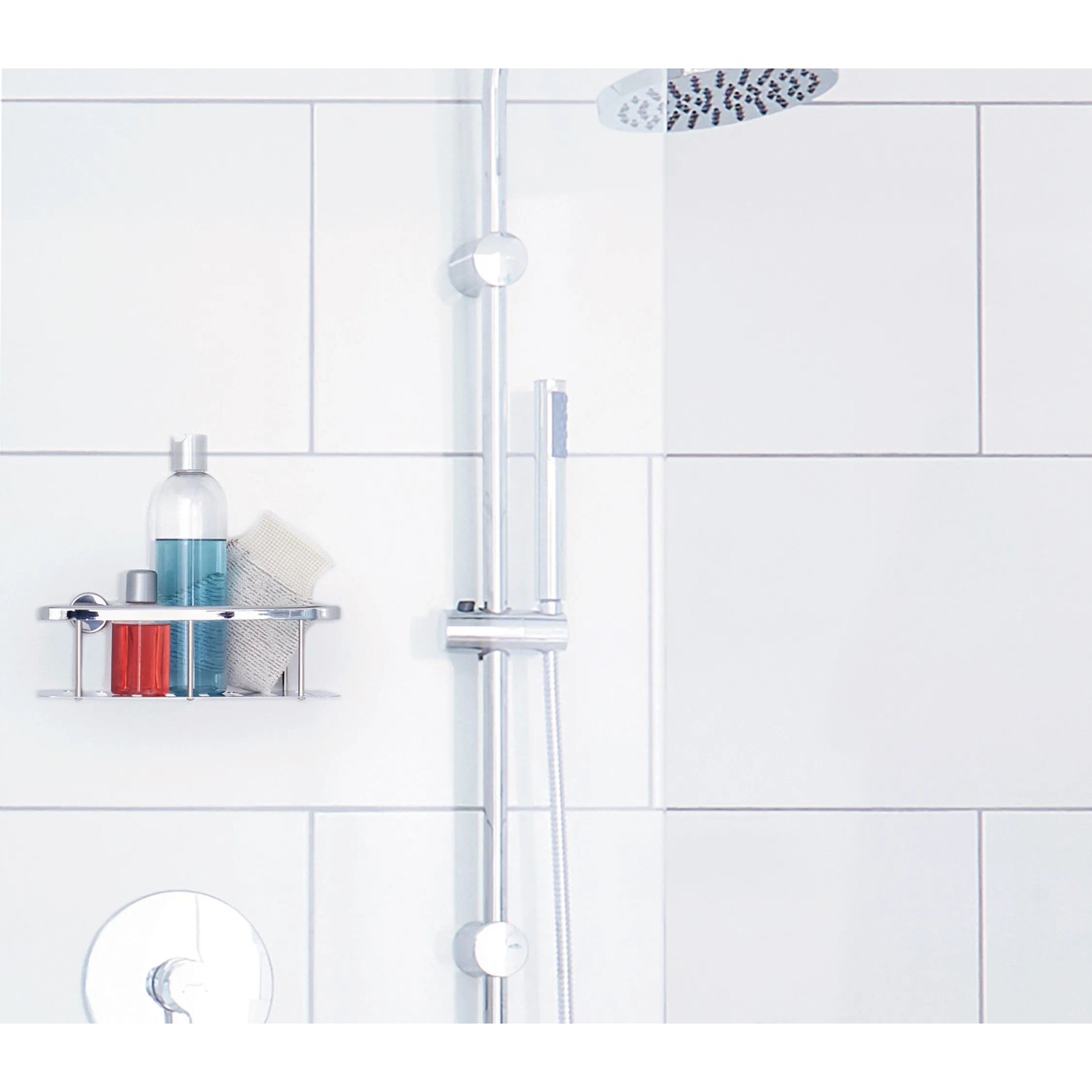 Verchromte Tesa Aluxx Duschablage mit Duschutensilien an weißer Wand.