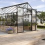Schwarzes Gewächshaus Cassandra 11500 ESG mit Doppelschiebetür und 4 Dachfenstern im Garten.