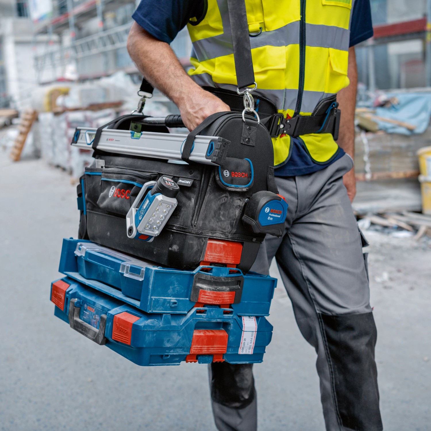 Bosch Professional Werkzeugtasche GWT 20 Set mit Werkzeug und Zubehör, getragen von einer Person.
