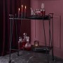 Schwarzer, runder Kerzenhalter aus Metall (Ø 7 cm, 9 cm hoch) auf einem Servierwagen dekoriert.