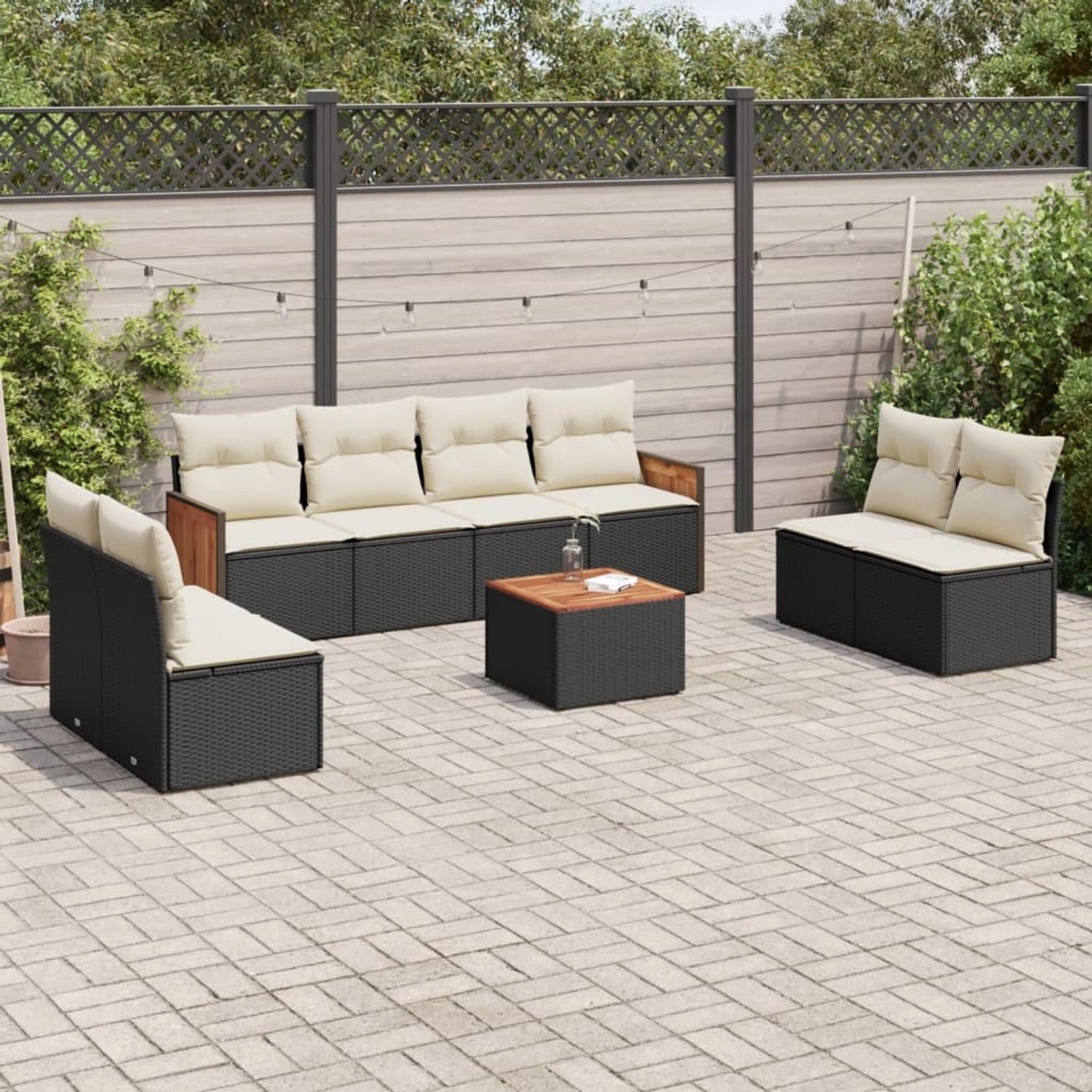 Schwarze 9-tlg. vidaXL Garten-Sofagarnitur aus Poly Rattan mit cremeweißen Kissen und Tisch auf einer Terrasse.