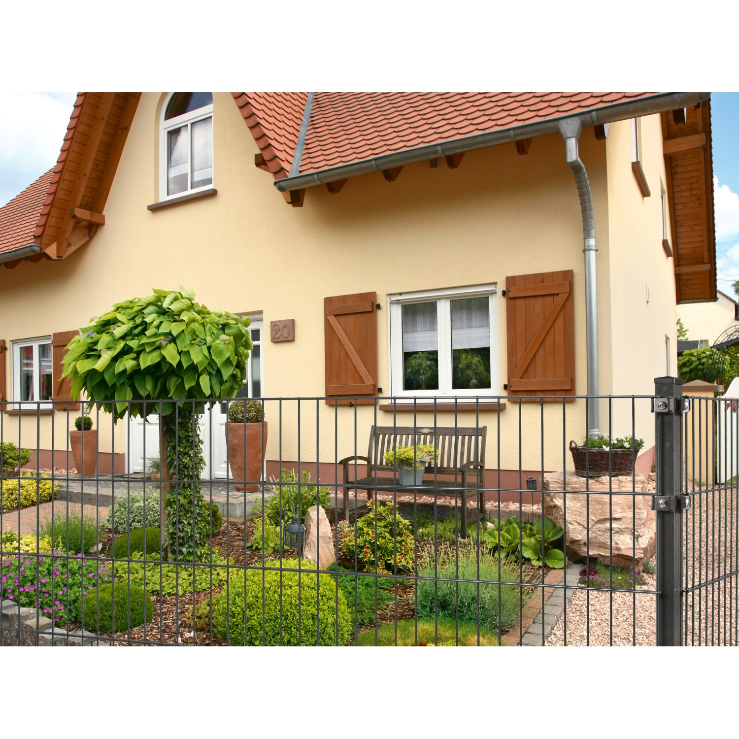 Anthrazit Doppelstabmattenzaun (183x201cm) umfriedet einen Garten mit Haus.