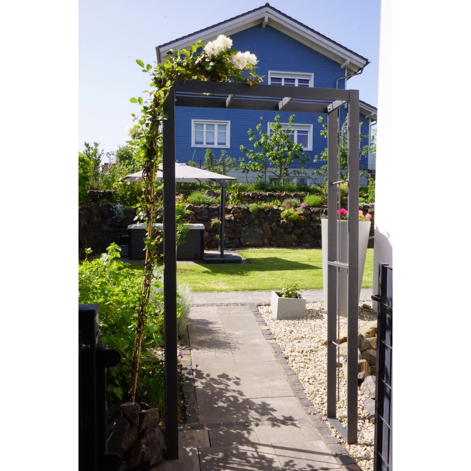 Anthrazit Rosenbogen Savona (230x124x37cm) im Garten mit Kletterpflanzen.