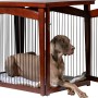 Großer, brauner Hundekäfig im Möbeldesign mit Hund darin. Der Hundezwinger ist auch als Beistelltisch nutzbar.