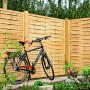 T & J Lamellenzaun, grün, 180x180 cm, mit Fahrrad davor. Sichtschutzzaun aus Holz für den Garten.