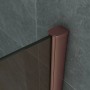 Nahaufnahme der Belvit Duschwand: bronzefarbenes 8mm Glas mit edlem Kupferprofil an grauer Wand.