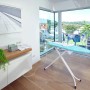 Leifheit Bügeltisch AirBoard Compact M Plus im modernen Wohnraum mit Wäscheständer im Hintergrund.