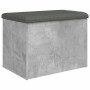 Betongraue Sitzbank mit Stauraum und dunkelgrauem Kissen. Möbel für Wohnzimmer oder Flur.