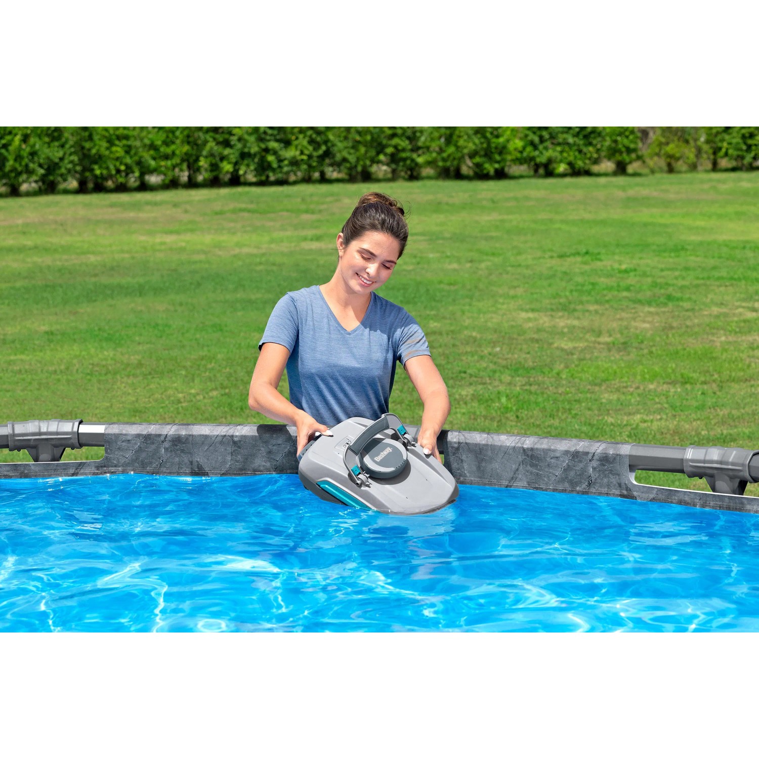 Frau setzt Bestway AquaTronix Pro G300 Poolroboter ins Wasser. Autonomer Poolreiniger mit Oberflächenskimmer.