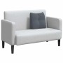 Dunkelgraues Samt-Rückenkissen auf einem hellen Sofa. Weiches Kissen für ergonomische Rückenunterstützung.