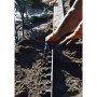 Einbau einer flexiblen, schwarzen Kunststoff Rasenkante/Beeteinfassung im Garten.