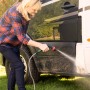 Frau reinigt Wohnmobil mit Bosch Akku-Druckreiniger Fontus 18V. Mobiler Hochdruckreiniger im Einsatz.