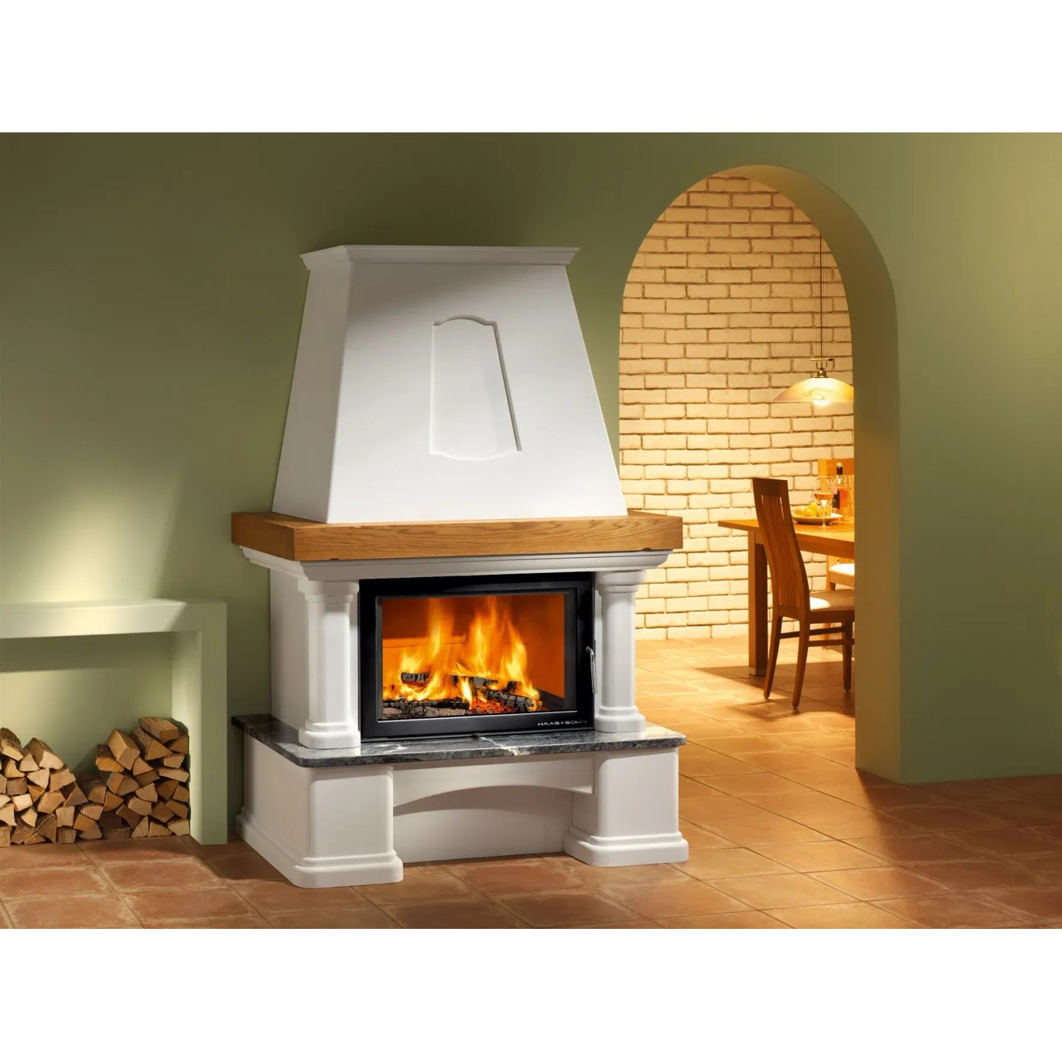 Weißer Haas+Sohn Genf II Kaminofen mit Holzfeuer und Wärmespeicherbeton im Wohnraum.