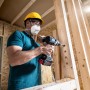 Handwerker bohrt mit Bosch Expert Flachfräsbohrer Löcher in Holzkonstruktion.