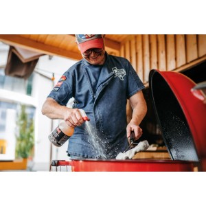 Mann reinigt roten Grill mit Ballistol Grillreiniger Pumpspray. Kraftvoller Aktiv-Schaum für effektive Fettlösekraft.