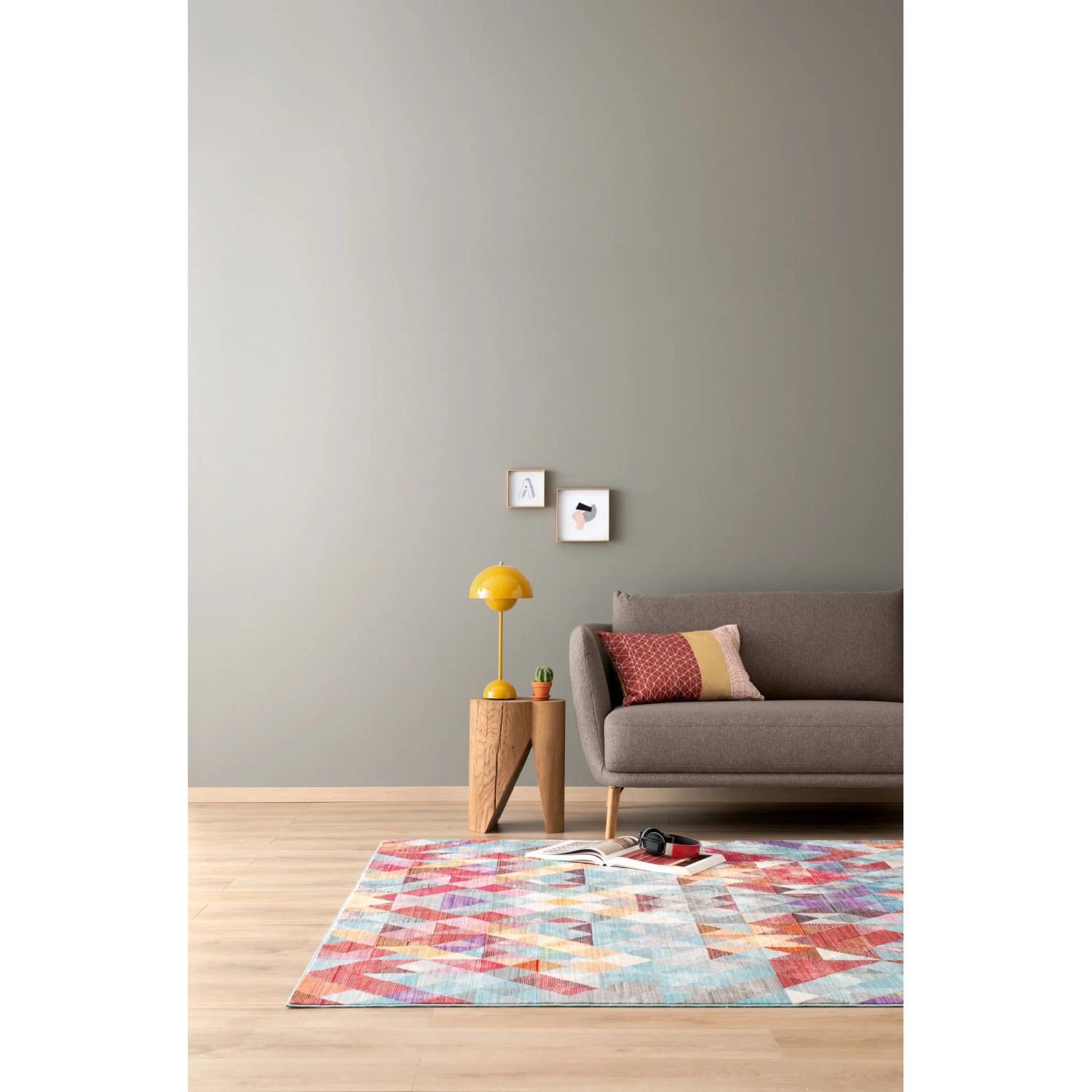 Wohnzimmer mit Schöner Wohnen Designfarbe Dynamisches Platingrau, Couch und Teppich.