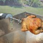 Grillspieß mit Hähnchen und Motor für gleichmäßiges Garen, Grillutensil.