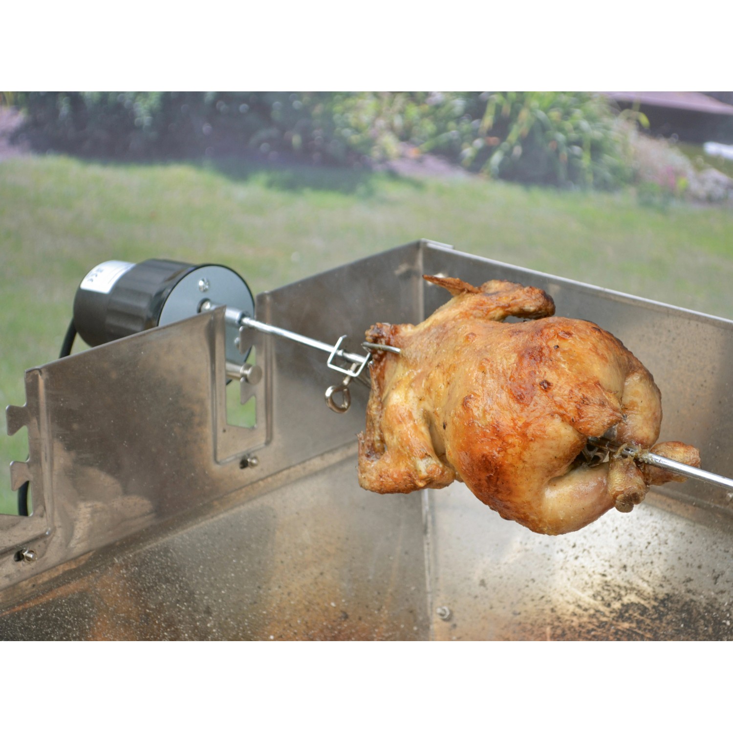 Grillspieß mit Hähnchen und Motor für gleichmäßiges Garen, Grillutensil.