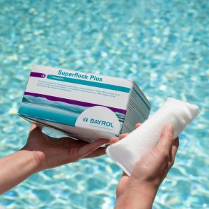 Bayrol Superflock Plus 1kg: Flockmittel Kartuschen für kristallklares Poolwasser in Händen vor Pool.