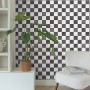 ESTAhome Karomuster Tapete in Schwarz-Weiß an Wand mit Deko-Elementen.