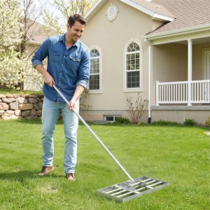 Mann ebnet Rasen mit Wiltec Edelstahl Rasenrakel. Ideal für Rasenpflege, Sanden und Flächenebnung im Garten.