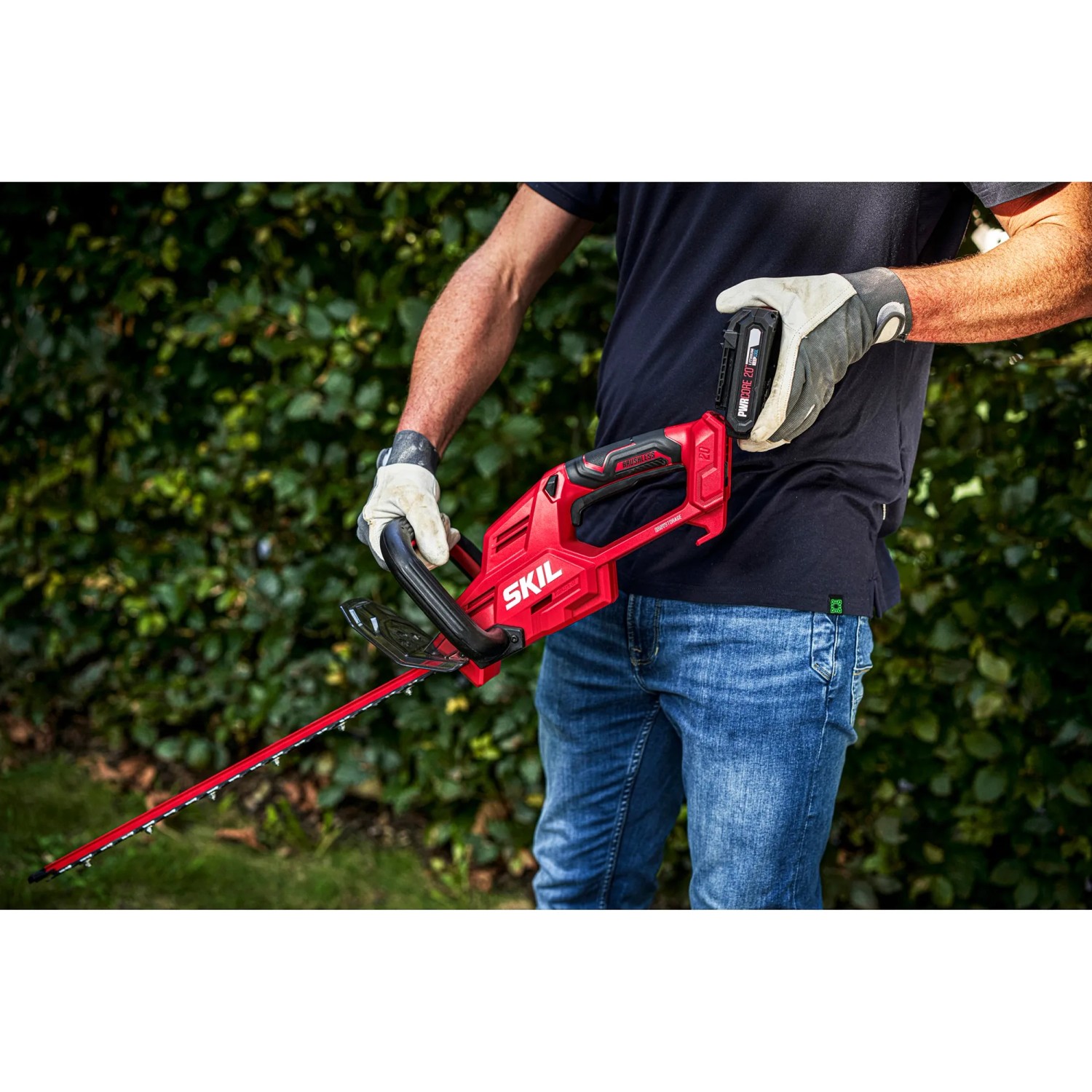 Skil Akku-Heckenschere 0438CA (ohne Akku/Ladegerät) in Nutzung, rot/schwarz, 45 cm Schnittlänge.