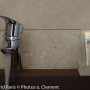 Grosfillex GX Wall+ Creme Slate Dekor-Paneele im Badezimmer mit Armatur und Wasser.