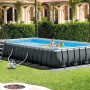 Intex Ultra Quadra XTR Stahlrahmen Pool Set mit Leiter, Filteranlage und Badenden im Garten.