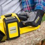Gelbe Kärcher Akku-Kettensäge CNS 18-30 Battery im Einsatz beim Sägen eines Baumstamms.