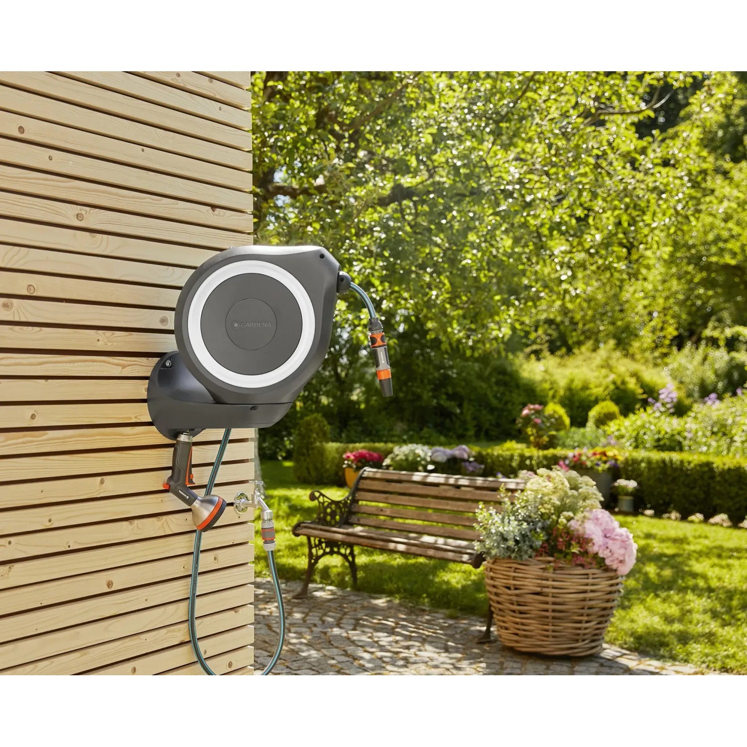 Gardena Wand-Schlauchbox RollUp M mit 20m Schlauch an Holzwand im Garten.