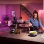 Philips Hue GU10 Starterset mit farbiger Beleuchtung in Küche, Wohnzimmer im Hintergrund.
