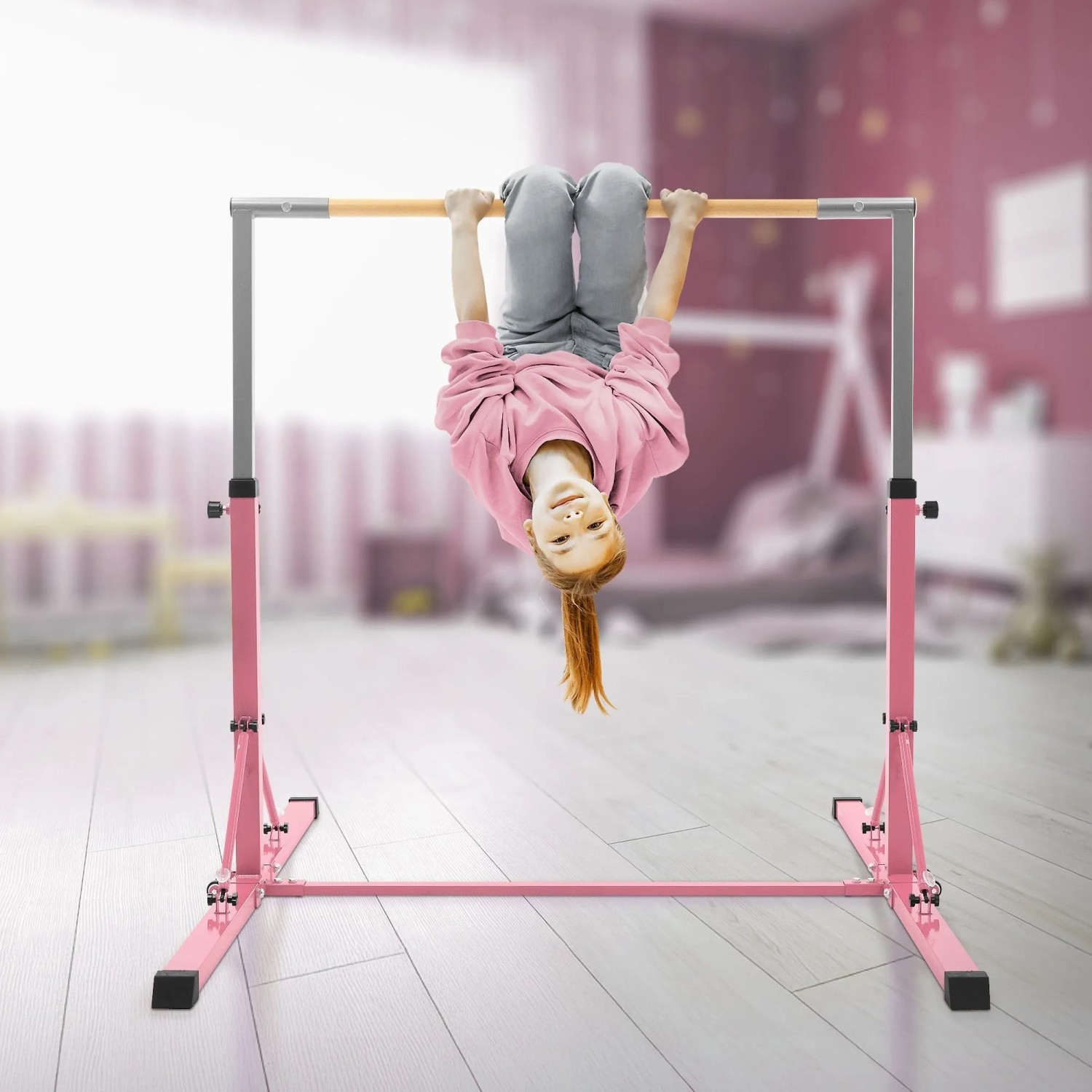 Pinkes, höhenverstellbares Gymnastik Turnreck mit Kind, das kopfüber daran hängt. Faltbares Sportgerät.