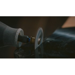 Dremel Rotationswerkzeug mit EZ SpeedClic Trennscheibe beim präzisen Schneiden einer dunklen Oberfläche.