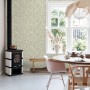 ESTAhome Vliestapete mit grünem Blumenmuster in hellem Raum mit Kamin und Esstisch. Dekorative Tapete.