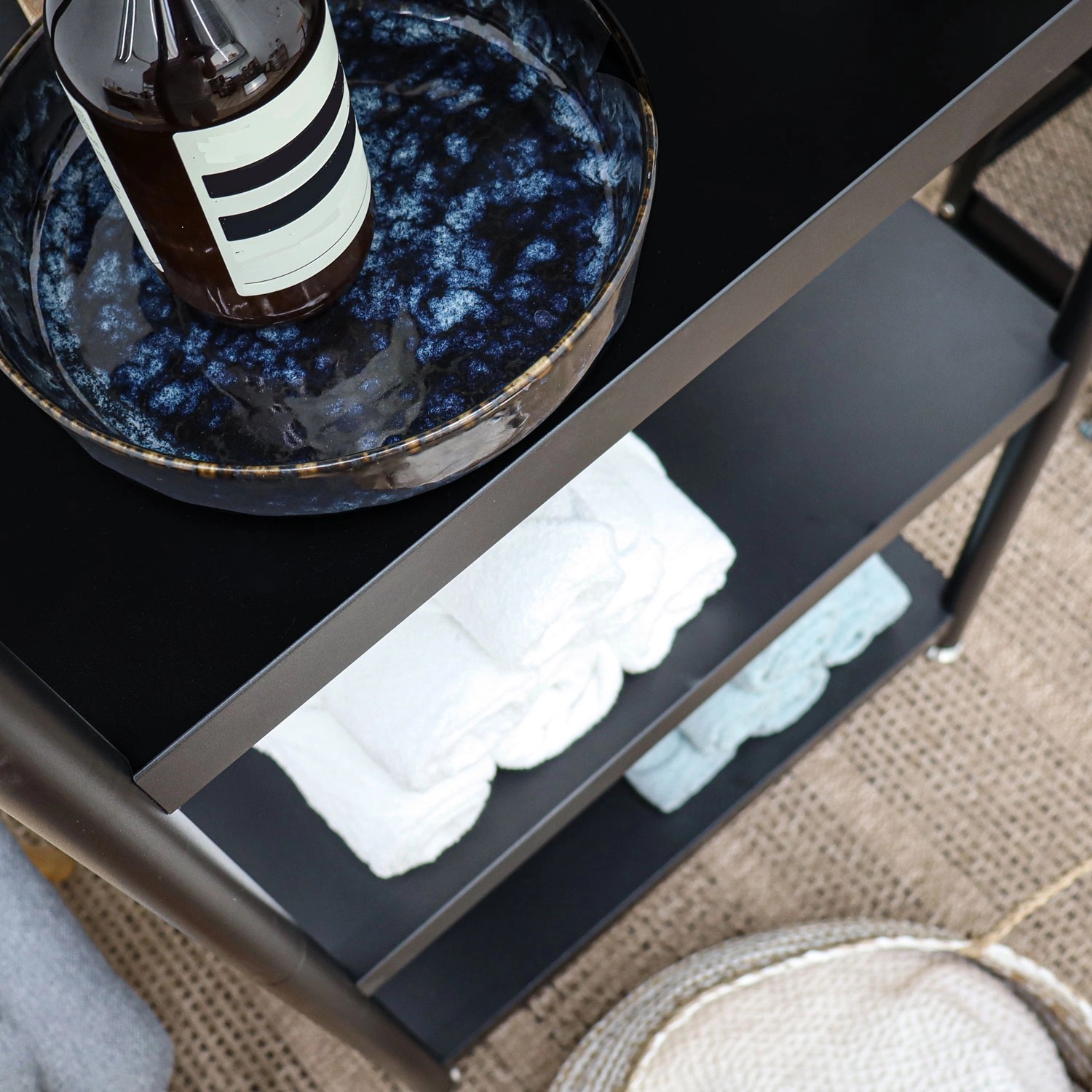 Schwarzes shelfr Metallregal mit 3 Ebenen, Ablage mit Deko und Handtüchern.