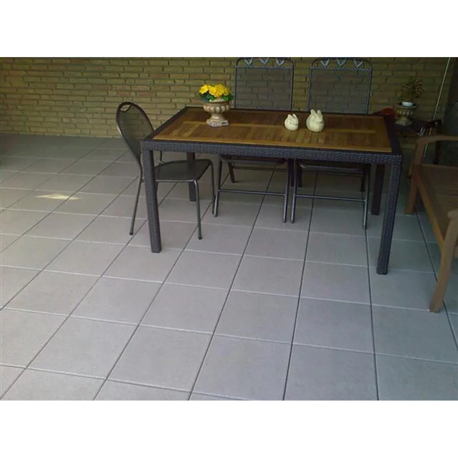 Verlegte Diephaus Finessa Terrassenplatten, mittelgrau, 40x40 cm, mit Tisch und Stühlen auf der Terrasse.