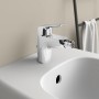 Ideal Standard Ceraflex Bidetarmatur in Chrom auf einem weißen Bidet.