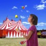 Mädchen jongliert bunte Jonglierbälle aus Kunststoff vor Zirkuszelt. 24er Set für Spiel & Spaß.