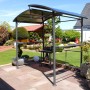 Leco Grillpavillon mit Polycarbonat-Dach in Anthrazit mit Ablagetischen und Grill im Garten.