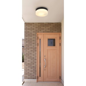 Schwarze, runde Globo Außendeckenleuchte aus Aluminium und Glas, montiert an einer Decke im Außenbereich.