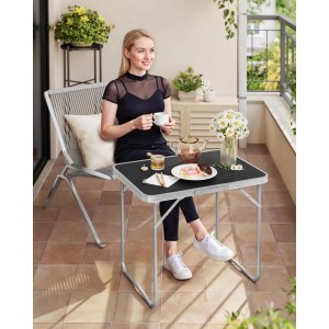 Schwarzer WOLTU Campingtisch Klapptisch aus Alu, zusammengeklappt auf einem Balkon mit Person.