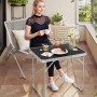 Schwarzer WOLTU Campingtisch Klapptisch aus Alu, zusammengeklappt auf einem Balkon mit Person.
